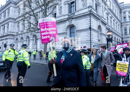 London, UK. 27th Nov, 2021. A protestor seen holding a placard that says 'Refugees welcome here' during the demonstration.Stand Up to Racism UK organized a protest against the Nationality and Borders Bill introduced by the Tory government. They called on the Boris Johnson and Priti Patel to open doors to more migrants, in light of a recent drowning of migrants on their way to the UK. Credit: SOPA Images Limited/Alamy Live News Stock Photo