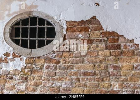 Brick and Stucco Wall  and a round window, textured exterior wall Stock Photo