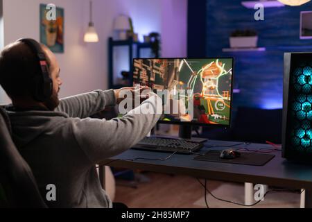 Adult using keyboard and mousepad to play video games on computer. Gamer  playing online game in