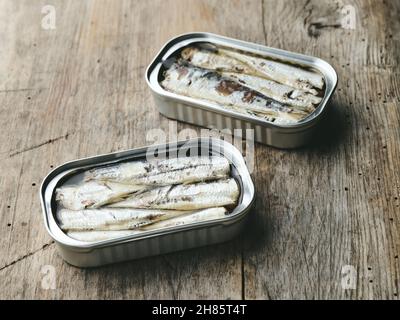 open sardines cans on rustic wooden kitchen table Stock Photo