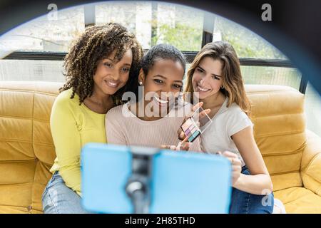 Young millennial girl friends recording video content on streaming platform Stock Photo