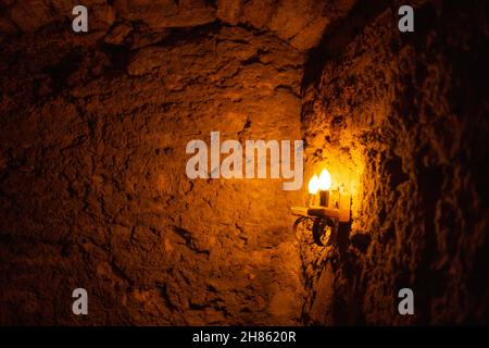Dim yellow light from a dim lamp in a stone cave Stock Photo