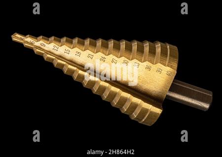 Conical step drill for drilling holes of different diameters, isolated on black background Stock Photo