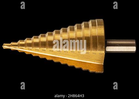 Conical step drill for drilling holes of different diameters, isolated on black background Stock Photo