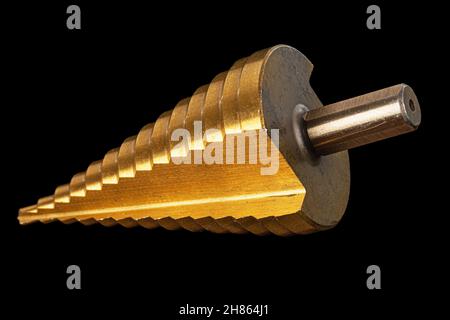 Conical step drill for drilling holes of different diameters, isolated on black background Stock Photo