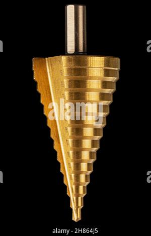 Conical step drill for drilling holes of different diameters, isolated on black background Stock Photo