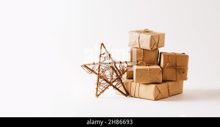 Handmade star, gifts in simple paper packaging light background. Festive composition for Christmas or New Year  Stock Photo