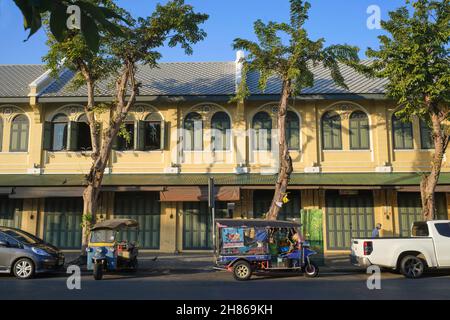 Old Thai-Chinese shophouses with tuk-tuks (three-wheeled taxis) parked in front in Maharat (Maha Rat) Road in the old city area of Bangkok, Thailand Stock Photo