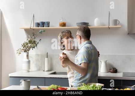 Happy elder couple having fun while preparing dinner Stock Photo