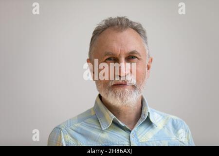 Serious older man in casual with beard head shot portrait Stock Photo