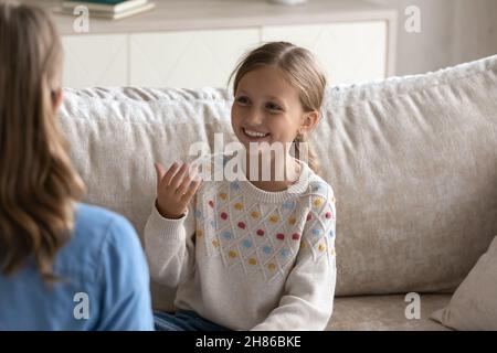 Smiling cute little girl practicing articulation with professional therapist. Stock Photo