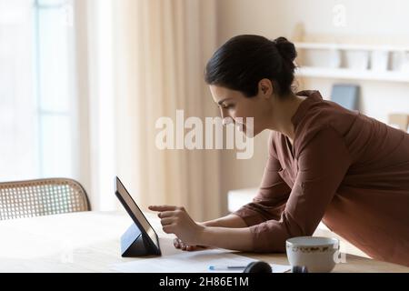 Smiling young indian woman using digital tablet. Stock Photo