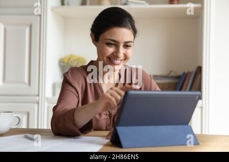 Happy indian woman using digital computer tablet. Stock Photo