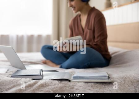 Focus on opened book with blurred indian woman on background. Stock Photo