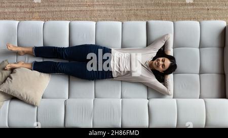 Above view smiling Asian woman relax on cozy sofa Stock Photo
