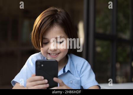 Boy looks at cellphone screen play videogame or having videocall Stock Photo
