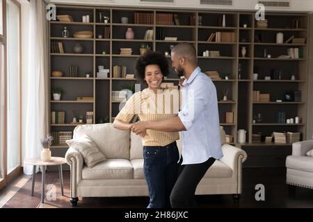 Excited millennial African American couple dancing together Stock Photo