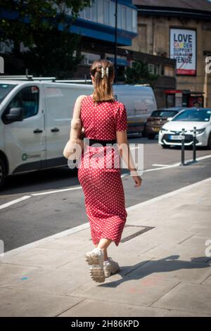 Elegant young woman wearing a white on red pokadot dress in Camden, London Stock Photo