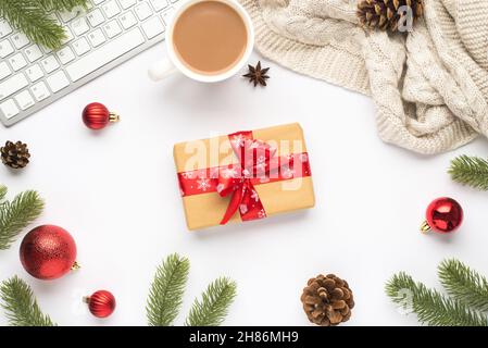 Top view photo of keyboard cup of hot drinking red christmas tree balls pine twigs cones anise sweater and giftbox with red bow on isolated white back Stock Photo