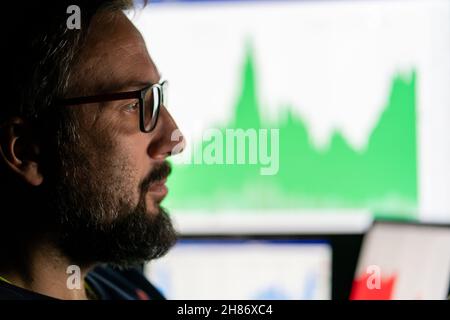 Crypto trader investor analyst looking at computer screen analyzing financial graph data on pc monitor, thinking of online stock exchange . Stock Photo
