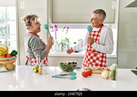 Senior caucasian couple smiling happy cooking at the kitchen. Stock Photo