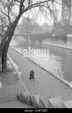 Toni Frissell - A Couple walk arm in arm along the Seine in Paris - Stock Photo