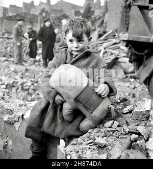 Toni Frissell Iconic photograph - Abandoned Boy holding a stuffed toy animal amid ruins following German air raid - London 1945 Stock Photo