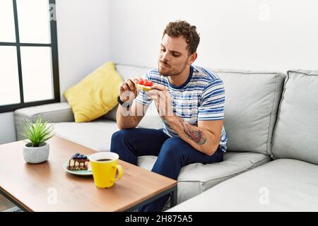 Young hispanic man having breakfast at home Stock Photo