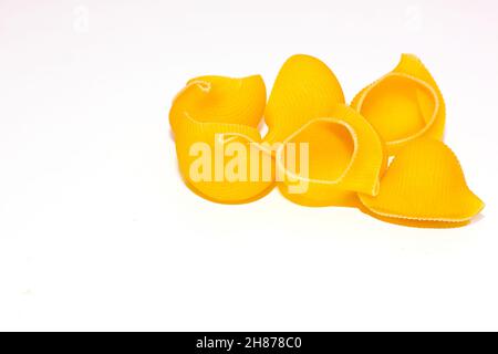 shell shaped pasta on a white background. A modern set for healthy eating, great design for any purpose. Vegetarian food. Isolated white background. Stock Photo