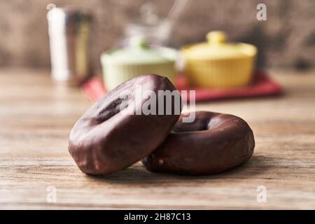 Two delicious chocolate doughnuts on a wooden surface Stock Photo