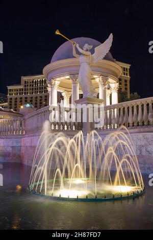 Las Vegas, Nevada, USA. Fountain outside Caesars Palace Hotel and Casino illuminated by night, statue of Fama in background. Stock Photo
