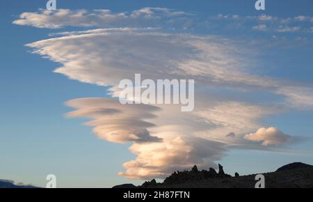 Alabama Hills National Scenic Area, Lone Pine, California, USA. Spectacular lenticular cloudscape above typical rock formations. Stock Photo