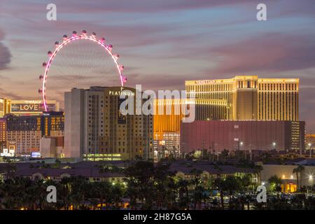 Las Vegas, Nevada, USA. Rooftop view over the city skyline at dusk, High Roller Ferris wheel and high-rise casino hotels illuminated. Stock Photo