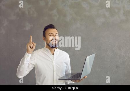 Smart business man working online holding laptop having idea studio shot Stock Photo