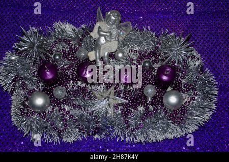 Advent wreath concept Christmas light violet background with candles ball bauble stars.Nice advent wreath with baubles and four burning purple candles Stock Photo