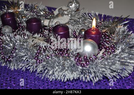 Christmas wreat in advent concept xmas light with candles ball bauble stars.Silver and violet advent wreath with baubles and burning purple candle Stock Photo