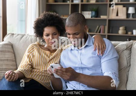 Couple using online app on cellphone, chatting on internet Stock Photo