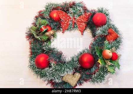 Christmas decorative wreath from tinsel of red Christmas balls and berries. Soft focus. Side view Stock Photo