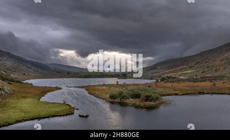 Epic aerial flying drone landscape image of Snowdon Massif viewed from above Llynau Mymber during Autumn sunset Stock Photo