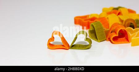 colored pasta in the shape of a heart on a light background. Healthy food concept. Soft focus Stock Photo