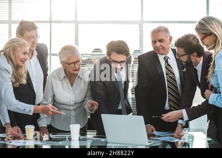 group of diverse specialists looking at the laptop screen Stock Photo