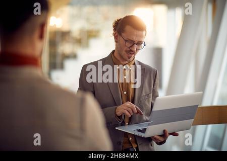 Business professional working on laptop in office lobby Stock Photo