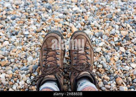 Close up of feet in walking boots, on shingle. August, 2021 Stock Photo