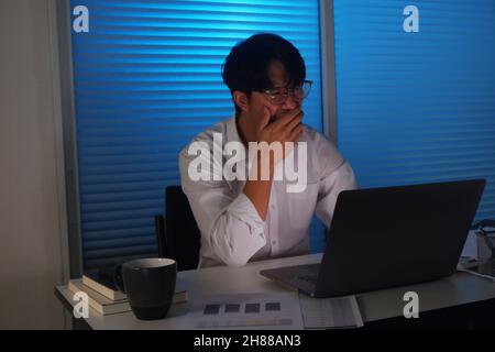 Young Asian businessman working late at night. Stock Photo