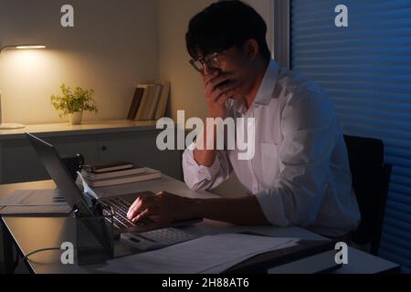 Young Asian businessman working late at night. Stock Photo