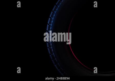 image photograph of a part of a tire with a winter tread on a black background Stock Photo