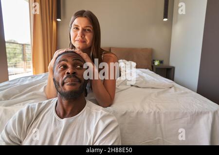 Joyous woman posing for camera with man in bedroom Stock Photo
