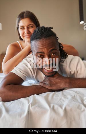 Joyous young couple posing for camera in bed Stock Photo