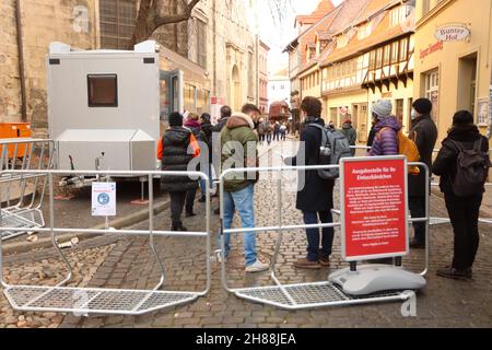 Quedlinburg, Germany. 28th Nov, 2021. Visitors wait in front of an issuing point for their admission wristbands for the Christmas market in the Advent city of Quedlinburg. The Christmas market is one of the two markets that have received a permit to open under particularly high Corona conditions in the district of Harz. Credit: Matthias Bein/dpa-Zentralbild/dpa/Alamy Live News Stock Photo