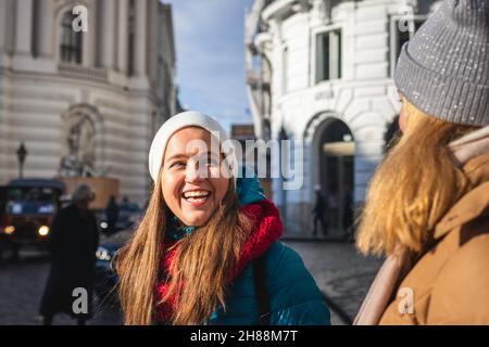 Two women having fun at city during vacation in Vienna, Austria. Young laughing woman and her friend near Hofburg complex. Happy smiling tourists Stock Photo